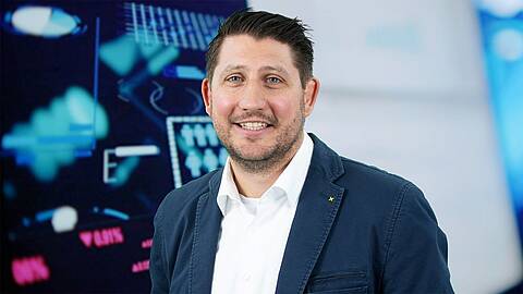 product manager for drives at KEB Automation, Tobias Wenneker, in front of the COMBIVIS dashboard on a big screen