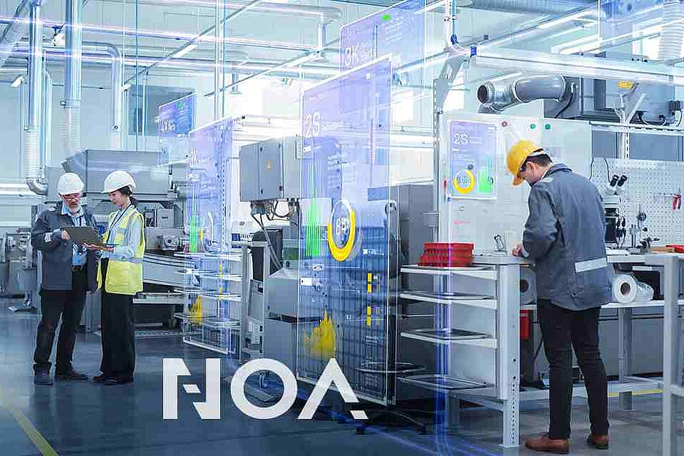 workers in a machine hall at assembly tables with the NOA logo