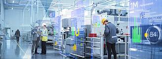 Thumbnail for the Webinar "NOA: These 5 features increase the value of your machine" by KEB Automation. Seen are workers in a machine hall at assembly tables and virtual HMIs in the air