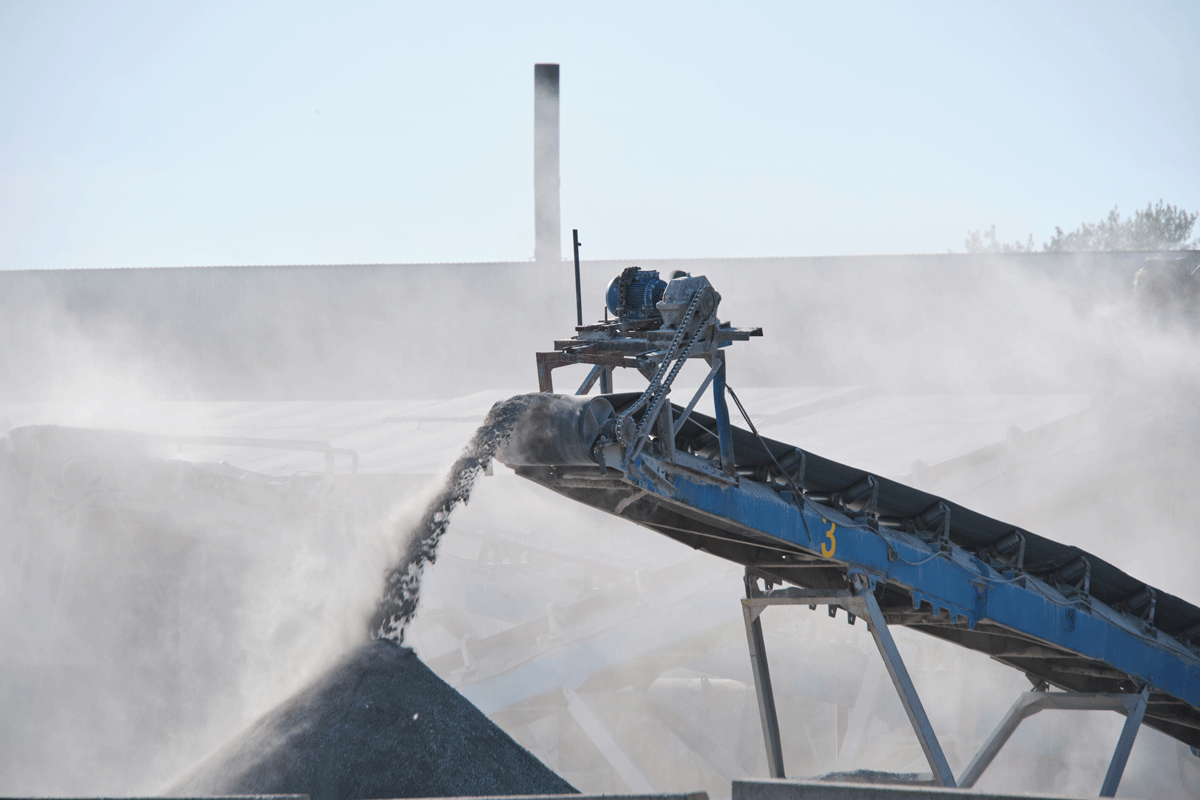 Conveyor belt of a crusher on a working site transporting and piling crushed material