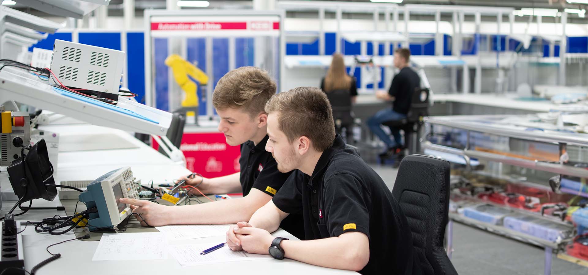 Young people sitting at a table in a hall and communicating with each other