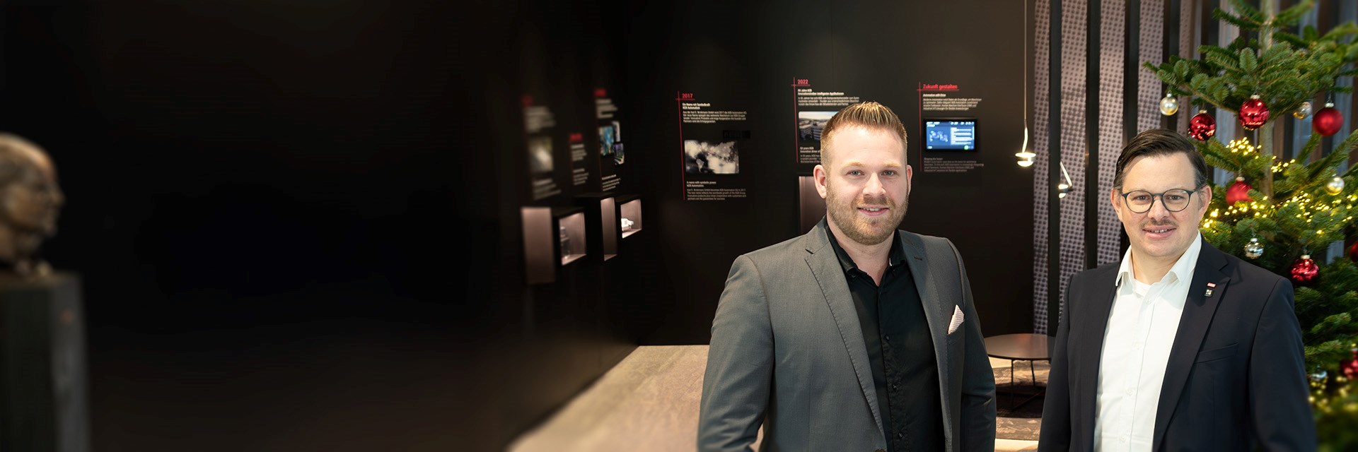 Kevin Zysk und Thomas Peters (beide Sales Management bei KEB Automation) in der KEB Lobby neben einem Weihnachtsbaum