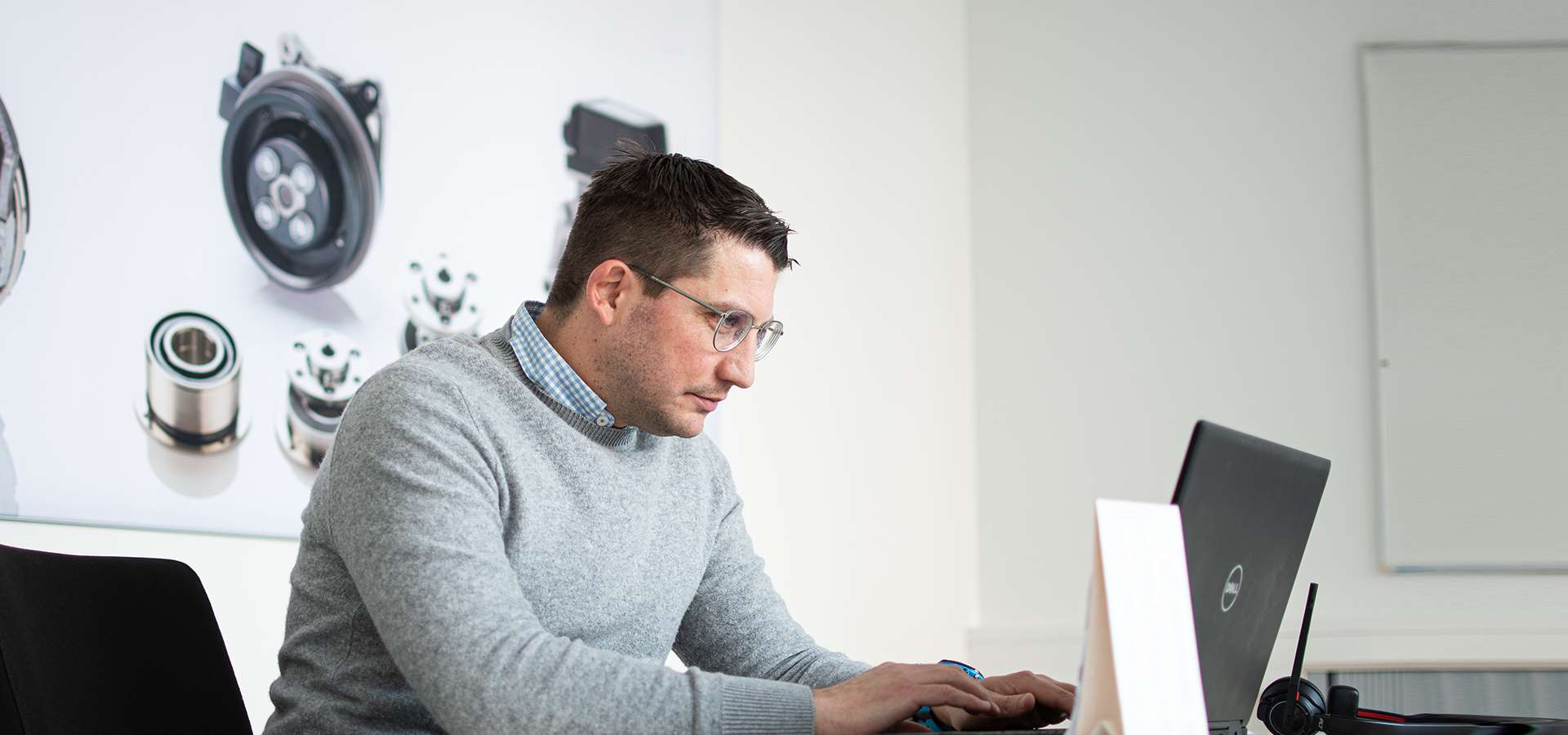 Mann sitzt am Schreibtisch und arbeitet am Notebook